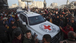 המון עזתי מקיף את רכבי הצלב האדום לפני שחרור ה חטופות אמילי דורון שטיינברכר ורומי גונן ב עזה 