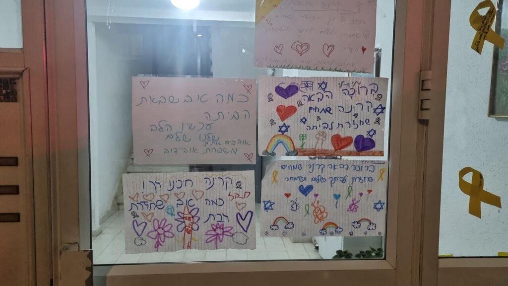 שלטים מחוץ לביתה של קרינה ארייב עם חזרתה