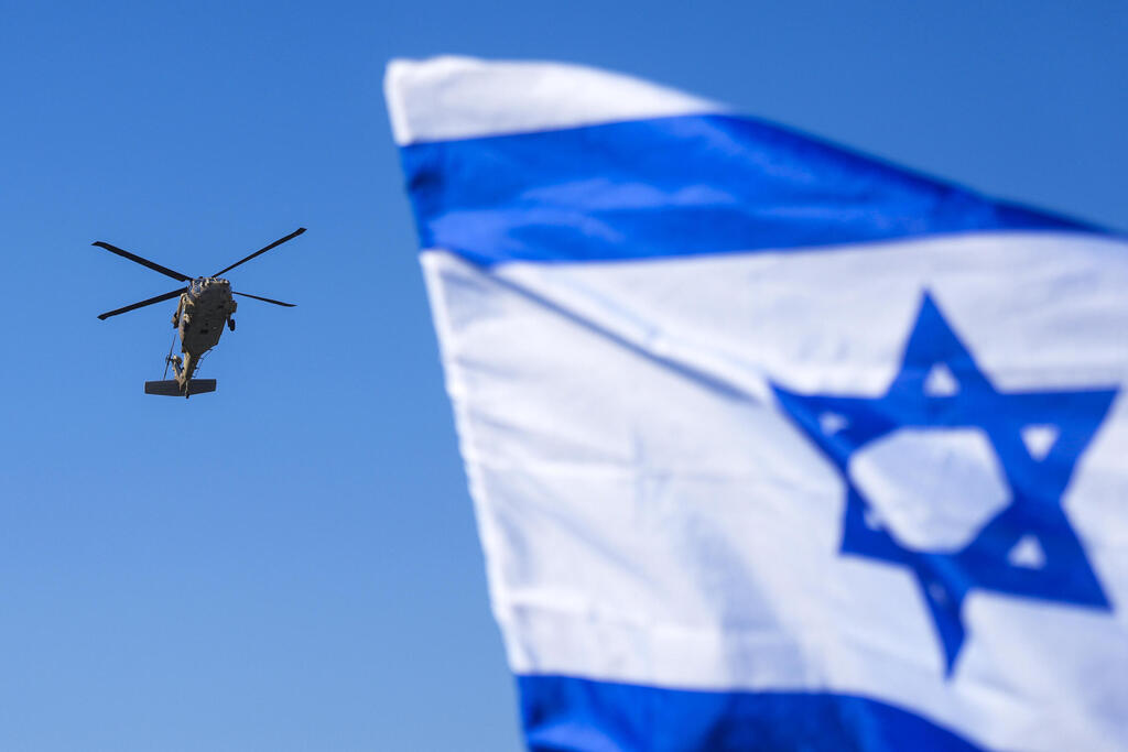 מסוק שנשא את החטופה אגם ברגר ל בית החולים בילינסון על רקע דגל ישראל אחרי שחרור מ רצועת עזה עסקה