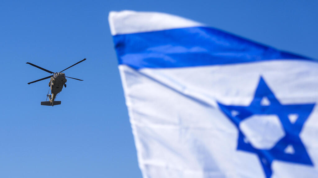מסוק שנשא את החטופה אגם ברגר ל בית החולים בילינסון על רקע דגל ישראל אחרי שחרור מ רצועת עזה עסקה