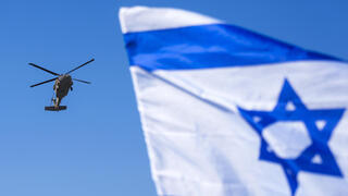 מסוק שנשא את החטופה אגם ברגר ל בית החולים בילינסון על רקע דגל ישראל אחרי שחרור מ רצועת עזה עסקה