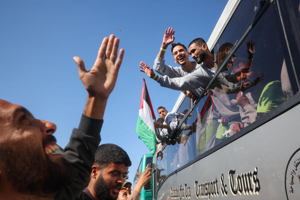 Palestinian prisoners celebrating release (Photo: Eyad Baba / AFP) אסירים פלסטינים מגיעים באוטובוסים לבית החולים האירופי בחאן יונס לבדיקות לאחר שחרורם בעסקה