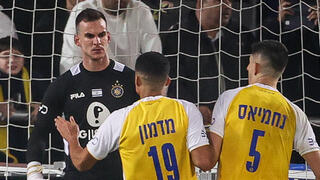 שחקני מכבי ת"א חוגגים עם סימון סלוגה אחרי עצירת הפנדל