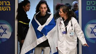 אליהו (אלי) שרעבי עטוף בדגל ישראל, עם הגעתו לבית החולים שיבא