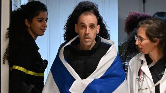 אליהו (אלי) שרעבי עטוף בדגל ישראל, עם הגעתו לבית החולים שיבא