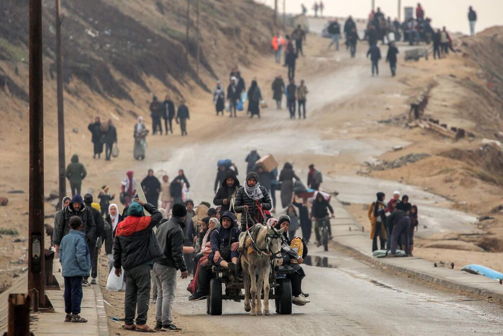 Gazans on the move following the opening of Netzarim Corridor (Photo: Eyad BABA / AFP) פליטים חוזרים לביתם ברצועת עזה