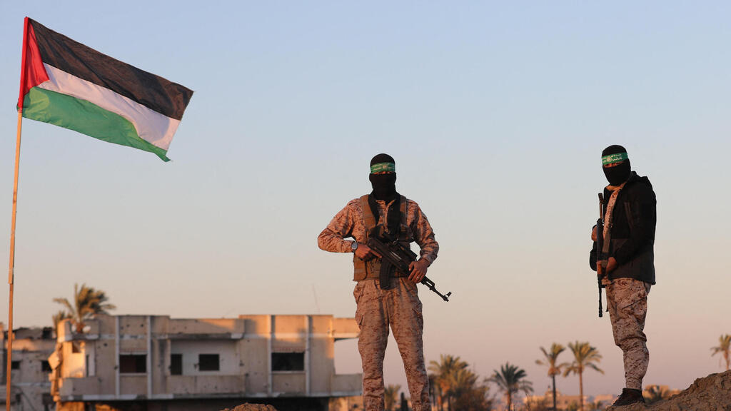 Hamas terrorists (Phסto: Reuters/ Ramadan Abed) מחבלי חמאס באיזור שחרור החטופים בעזה