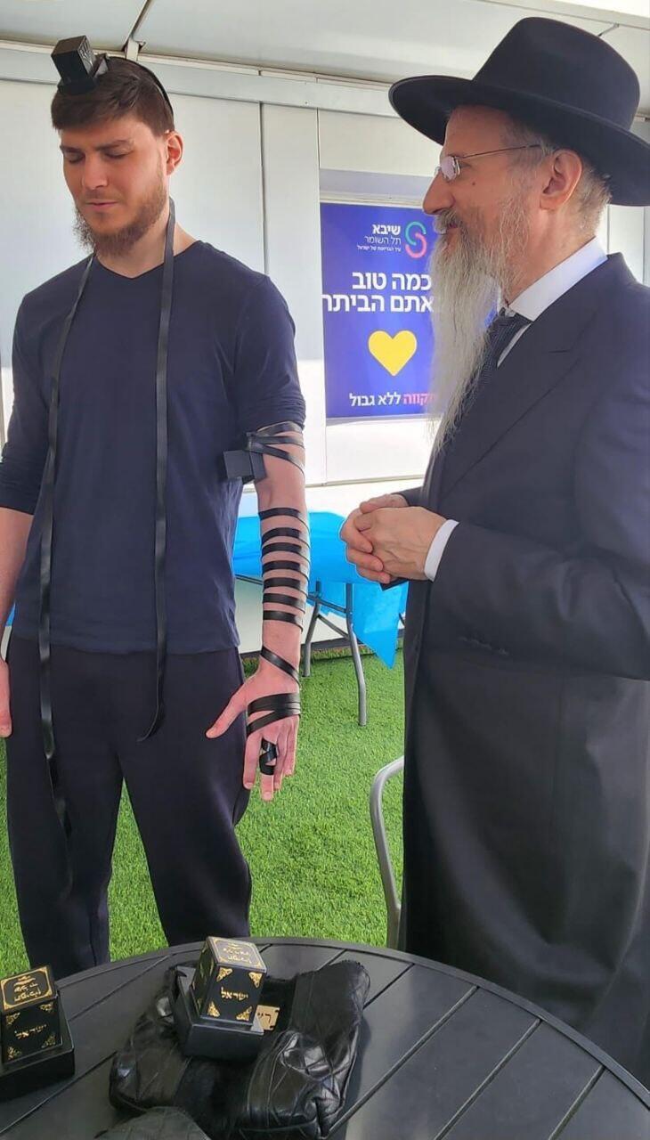 סשה טרופנוב מניח תפילין עם רבה הראשי של רוסיה הרב לאזאר