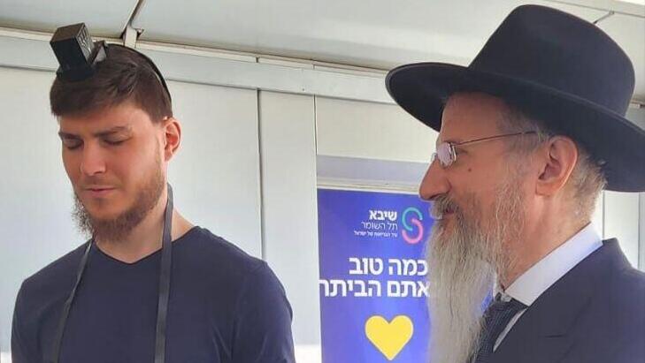 סשה טרופנוב מניח תפילין עם רבה הראשי של רוסיה הרב לאזאר