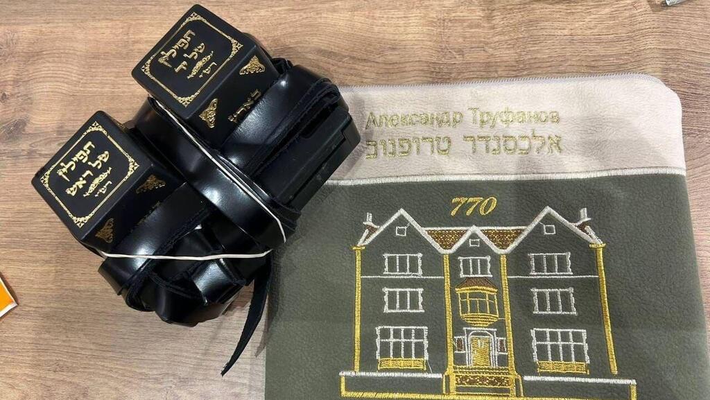 סשה טרופנוב מניח תפילין עם רבה הראשי של רוסיה הרב לאזאר