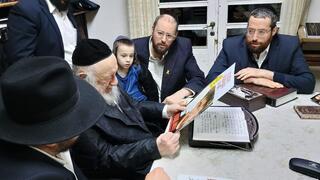 הרב ברוך דב פוברסקי מחזיק את תמונת אחד החטופים