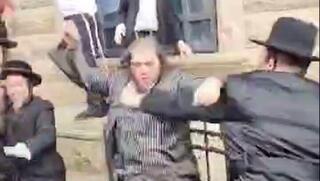 עימות בין חסידים מחוץ לבית המדרש של חסידות קרלין
