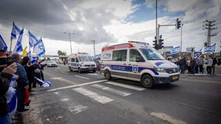 אזרחים תומכים בצומת אשקלון במהלך קבלת החטופים החללים והעברתן לאבו כביר