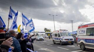 אזרחים תומכים בצומת אשקלון במהלך קבלת החטופים החללים והעברתן לאבו כביר