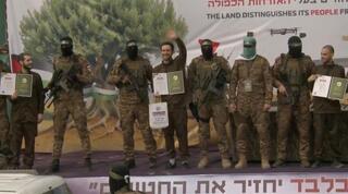 Israeli hostages Eliya Cohen, Omer Shem Tov and Omer Wenkert paraded onto a stage in Nuseirat, central Gaza Strip, ahead of their release 