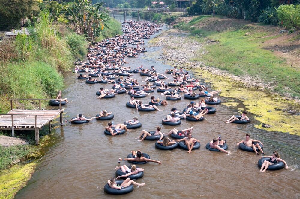 תיירים שטים באבובים בנהר פאי