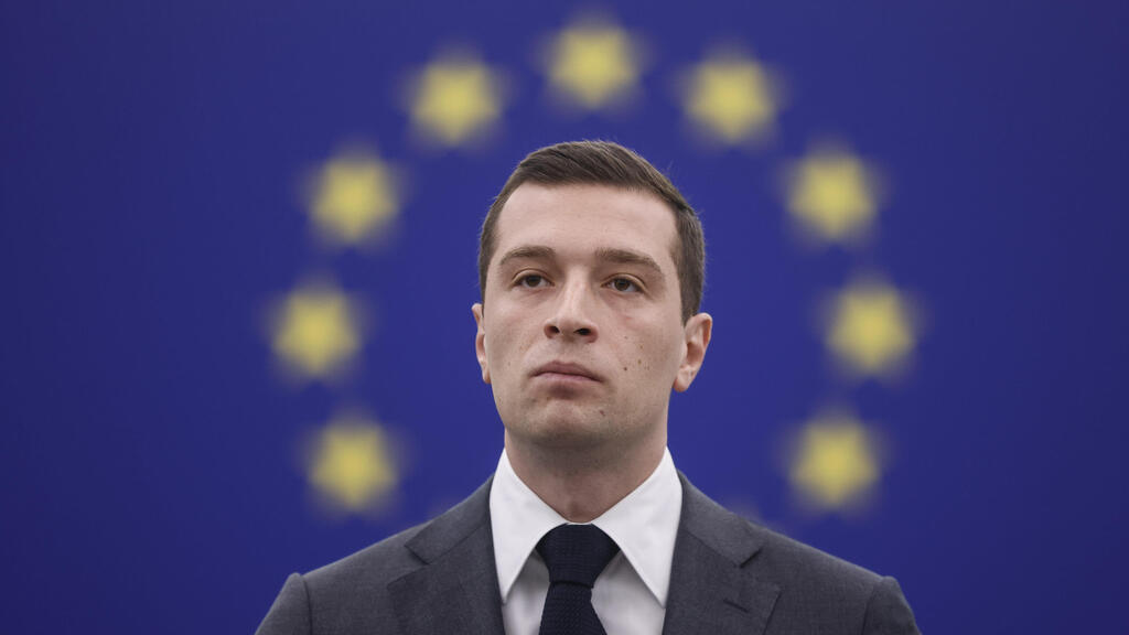 Jordan Bardella, president of France's National Rally party (Photo: Jean-Francois Badias, File) ז'ורדן ברדלה נשיא מפלגת האיחוד הלאומי בצרפת ארכיון 2024 על רקע דגל האיחוד האירופי