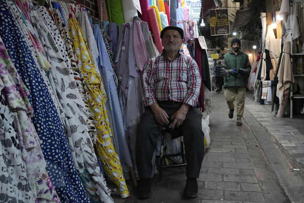 Store owner sits outside in Tehran's market 