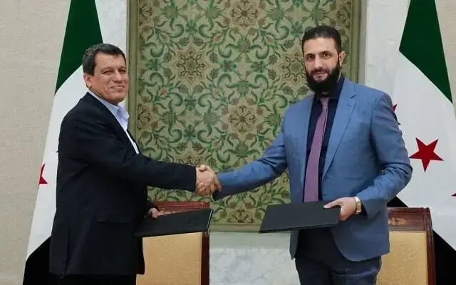 Syria’s interim president Ahmed al-Sharaa (R) and Syrian Democratic Forces (SDF) commander-in-chief Mazloum Abdi signing an agreement to integrate the institutions of the semi-autonomous Kurdish administration 
