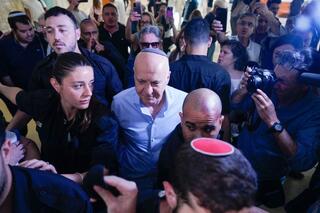 יורם כהן יוצא מהאולם בזמן שאזרחים מקיפים אותו בצעקות "בושה"