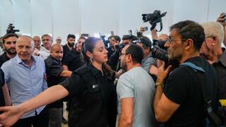 יורם כהן יוצא מהאולם בזמן שאזרחים מקיפים אותו בצעקות "בושה"