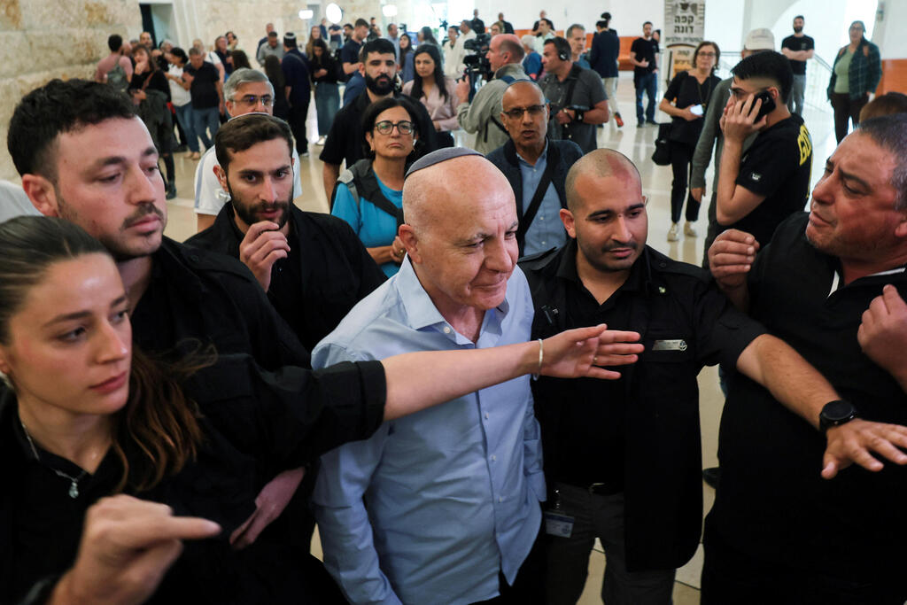 יורם כהן יוצא מהאולם בזמן שאזרחים מקיפים אותו בצעקות "בושה"