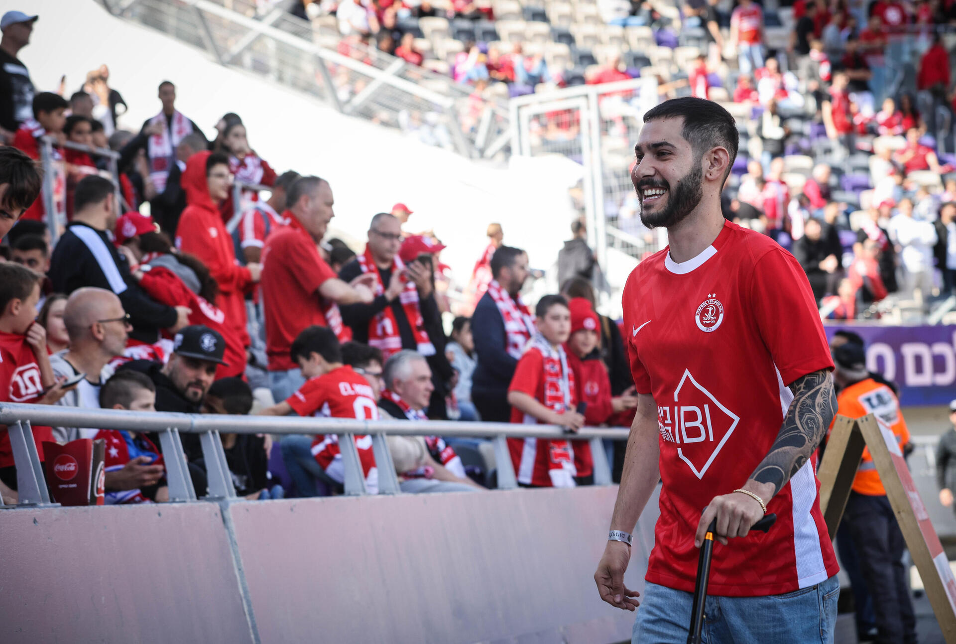 אדום בלב. שורד השבי אלי-ה כהן מתקבל באהבה גדולה במשחק בין הפועל ת"א להפועל פ"ת  