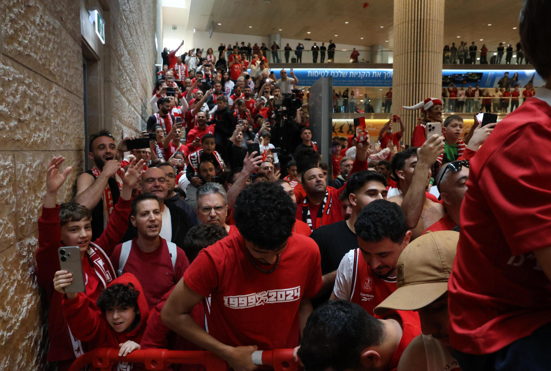 אוהדי ושחקני הפועל תל-אביב נוחתים עם הגביע, אחרי הזכייה ביורוקאפ  