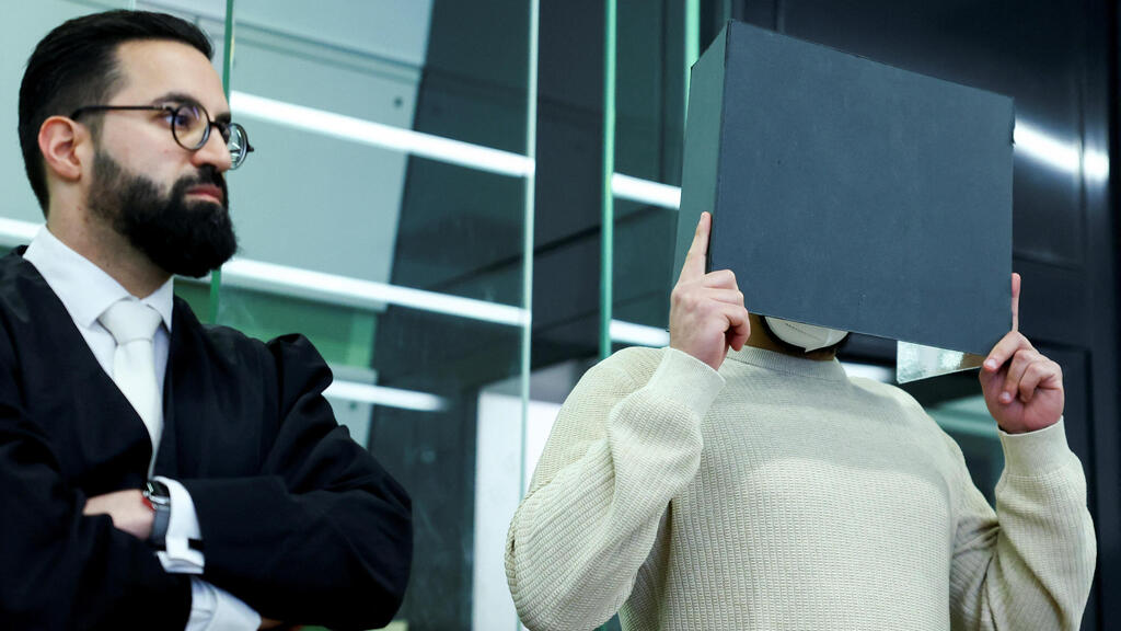 The attacker, who is hiding his face, and his attorney (Photo: Lisi Niesne/Reuters) התוקף (מסתיר את פניו) ועורך דינו בבית המשפט