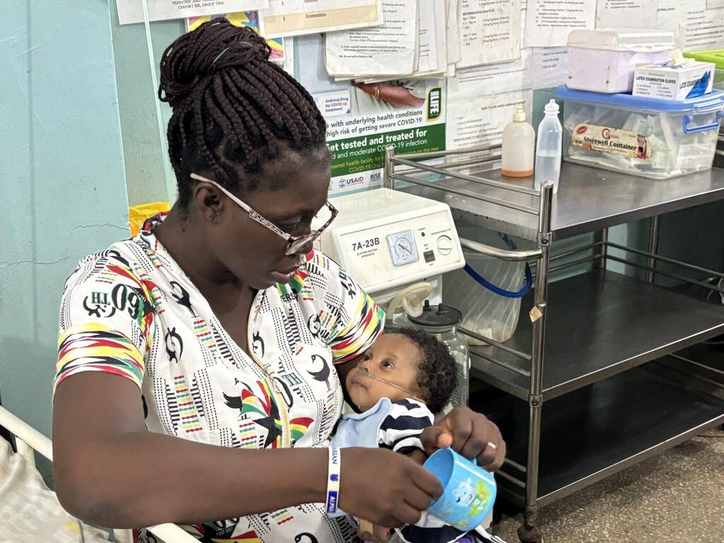 A Ghanaian mother comforts her sick baby 