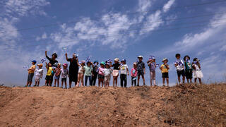 ילדי קיבוץ עלומים מנופפים בגדלי ישראל