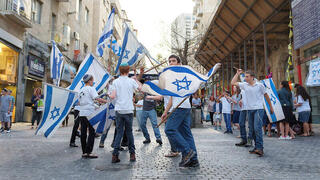 Isareli youth dancing with flags in Jerusalem Day celebrations 