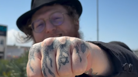 הרב דוד ברסלבסקי מציג את הקעקועים שעל ידו