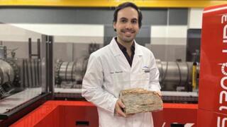 One of the oldest known rock deposits lies in the Jack Hills of Western Australia, containing crystals of the mineral zircon. A researcher holds a rock sample from the Jack Hills
