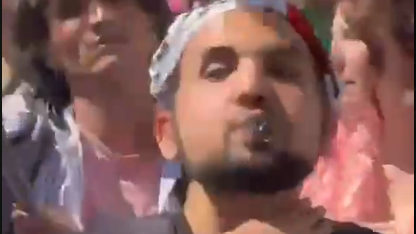 Palestinian protester makes threatening gesture during the Eurovision Song Contest events (Screenshot ) תנועת שחיטה