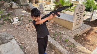 A boy plays with a toy gun in a Nablus refugee camp