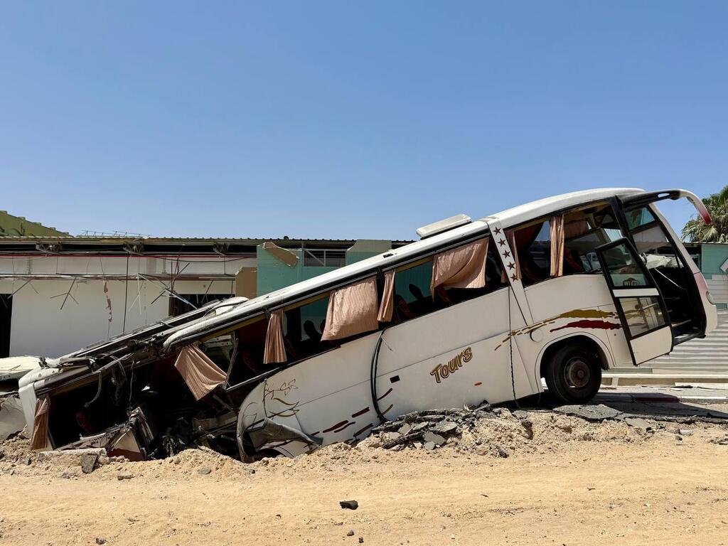 A bus lies partially swallowed by a collapsed section of road caused by one of the blasts outside the European Hospital in Khan Younis (Photo: Roni Green Shulov) הכתב רוני גרין שאולוב בבית החולים האירופי בחאן יונס ברצועת עזה