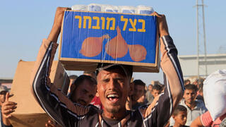 פלסטיני סוחב סיוע הומניטרי