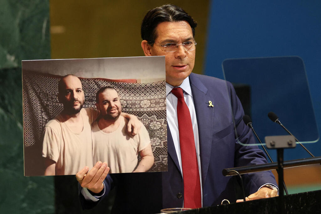 Israel's ambassador to the UN Danny Danon holds photo of two Israeli hostages as he speaks to the General Assembly before a vote on a draft resolution demanding a ceasefire in Gaza 
