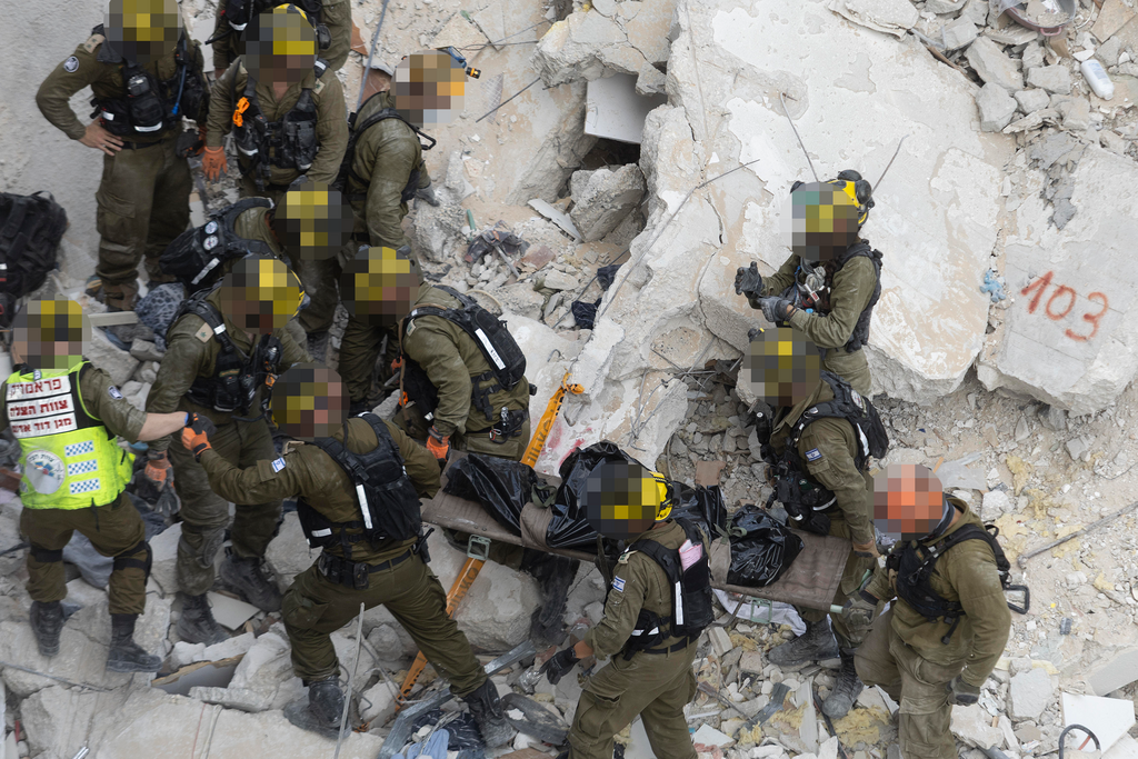 Rescue teams remove people from the rubble after a missile strike on central Israel on Sunday (Photo: Amir Levy / Getty Images) פגיעה ישירה בבת ים