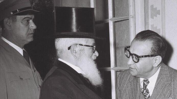 הרב הראשי לישראל הרב יצחק אייזיק הלוי הרצוג, בשיחה עם רזא סאפיניה, הנציג האיראני המיוחד בישראל במסיבת קוקטיילים בימק"א, 1950