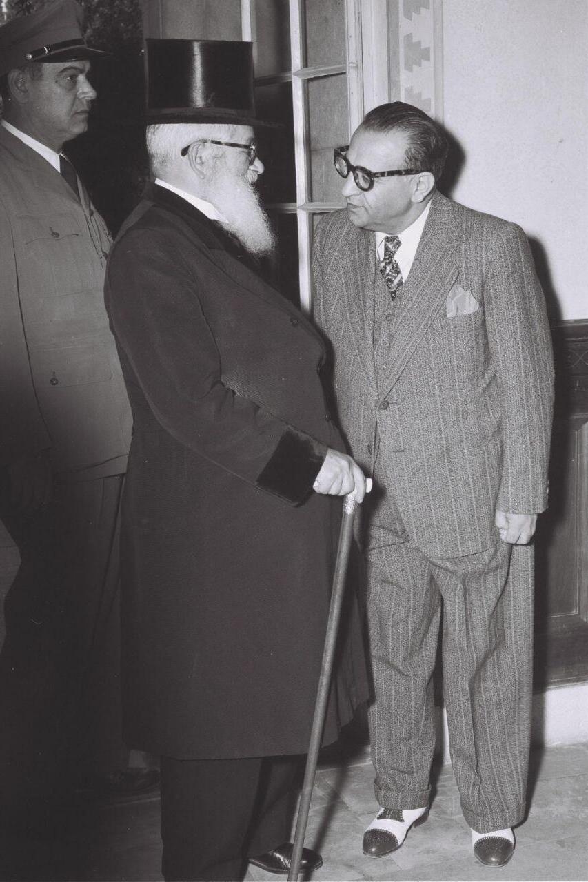 Chief Rabbi of Israel Rabbi Yitzhak Isaac HaLevi Herzog, in conversation with Reza Safinia, the special Iranian representative in Israel (Photo: Teddy Brauner/GPO) הרב הראשי לישראל הרב יצחק אייזיק הלוי הרצוג, בשיחה עם רזא סאפיניה, הנציג האיראני המיוחד בישראל במסיבת קוקטיילים בימק"א, 1950