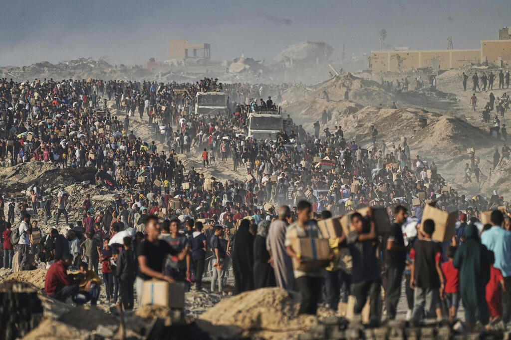 Palestinians carry humanitarian aid parcels in southern Gaza (Photo: AP Photo/Jehad Alshrafi) פלסטינים נושאים שקים וקופסאות של מזון וסיוע הומניטרי
