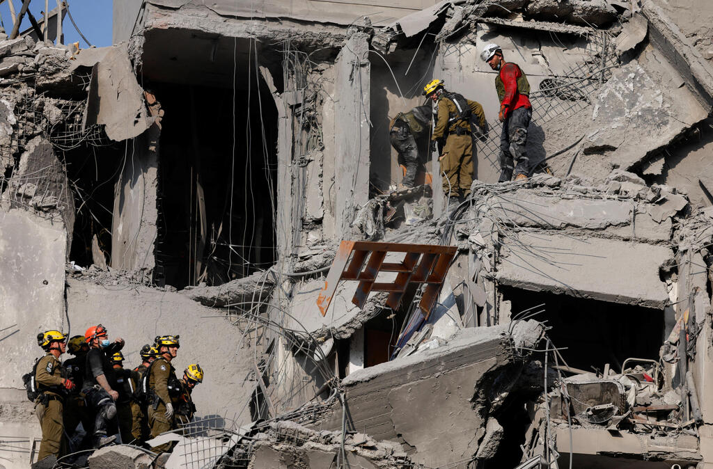 Rescue workers in the ruins of the apartment building, that took a direct hit from an Iranian missile (Photo: Amir Cohen/Reuters) הריסות בזירת הנפילה בבאר שבע