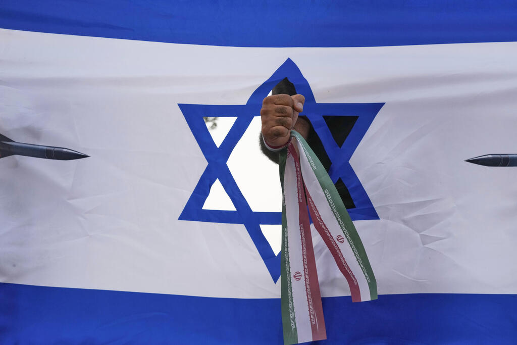 איראן טהרן תומך משטר מניף אגרוף עם סרט איראני דרך דגל ישראל