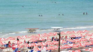 אנשים מבלים בחוף הים במהלך גל חום קיצוני