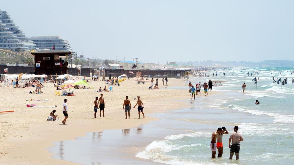 Photo: Kobi Koanks אנשים מבלים בחוף הים במהלך גל חום קיצוני
