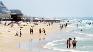 אנשים מבלים בחוף הים במהלך גל חום קיצוני