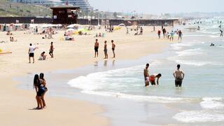 אנשים מבלים בחוף הים במהלך גל חום קיצוני