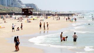 אנשים מבלים בחוף הים במהלך גל חום קיצוני